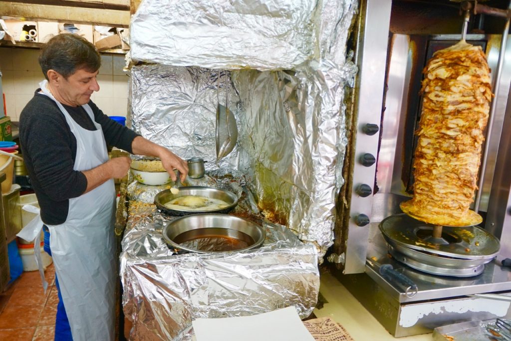 Fresh felafel balls being dripped into the fryer, next to the chicken shwarma